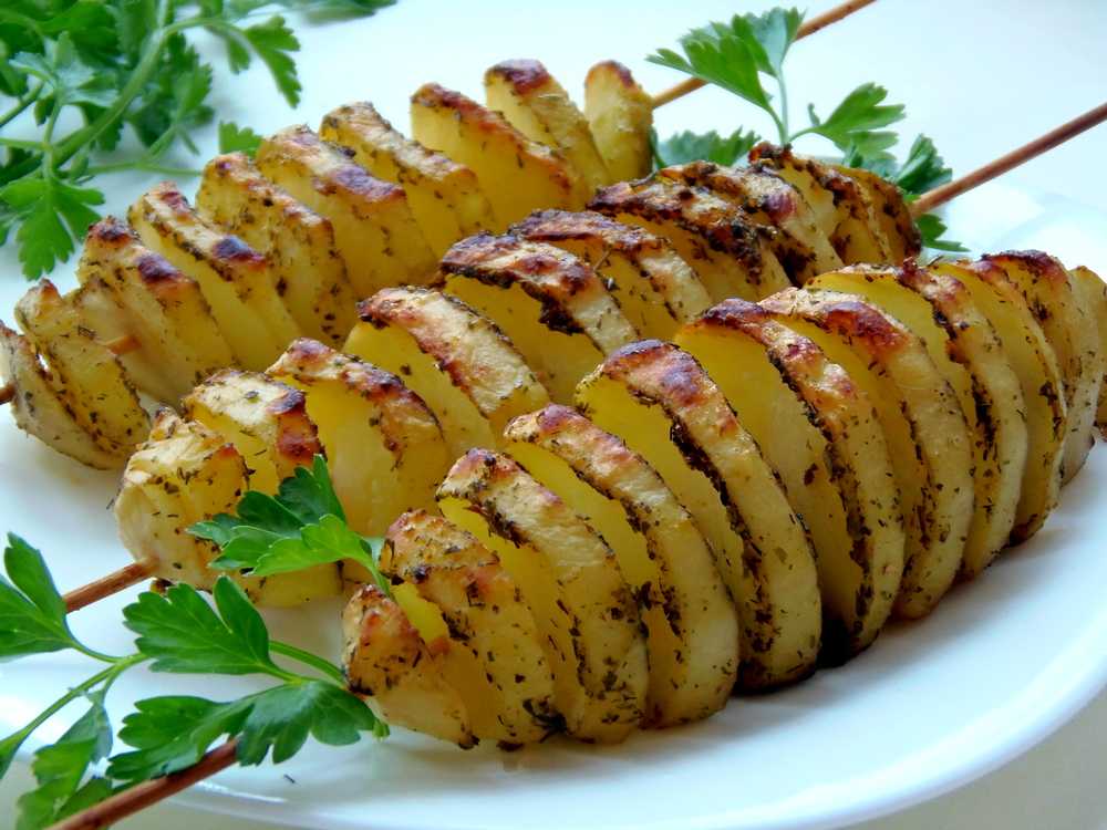 Запечь картошку в духовке рецепты простые. Запеченный картофель. Картофель в духовке. Картошка в духовке запеченная. Картофель на шпажках в духовке.