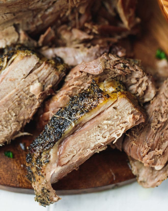 Slow cooked leg of lamb sliced on a cutting board