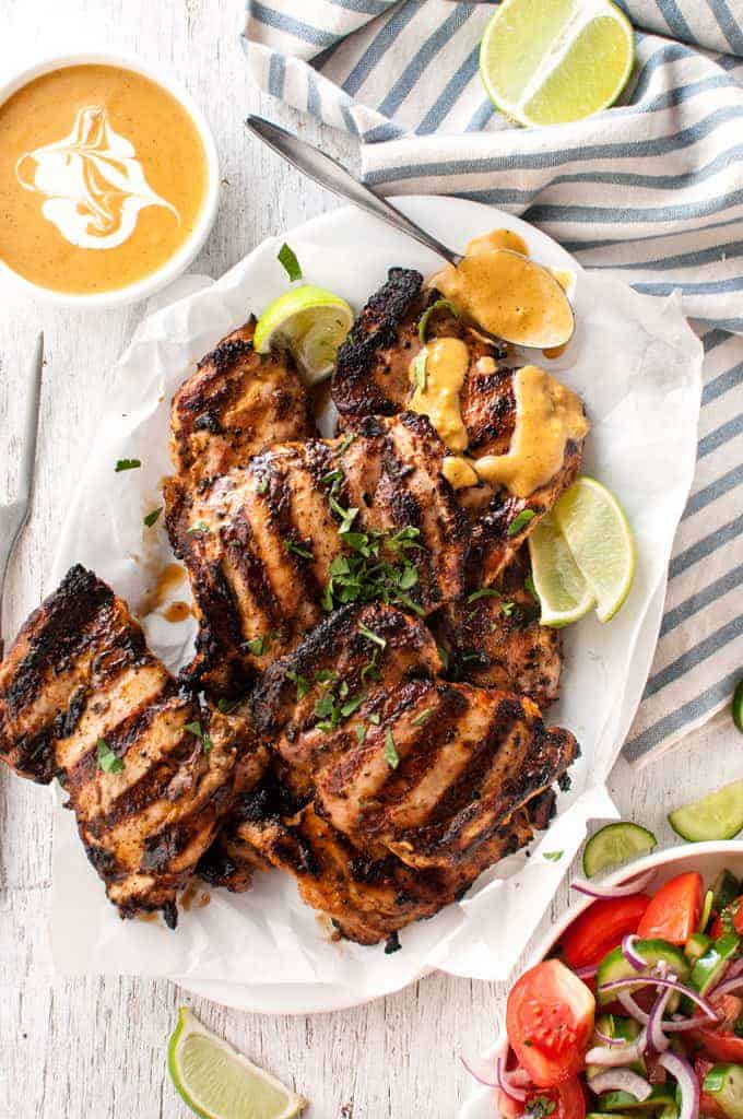 Grilled Coconut Marinated Chicken on a plate, drizzled with coconut sauce.