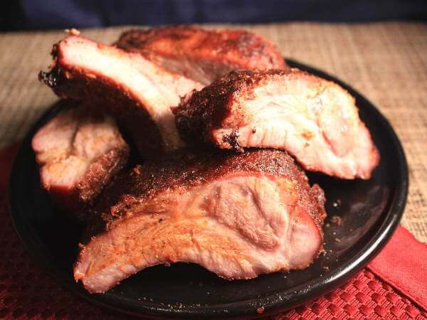 Pile of Smoked Baby Back Ribs On Dark Blue Plate