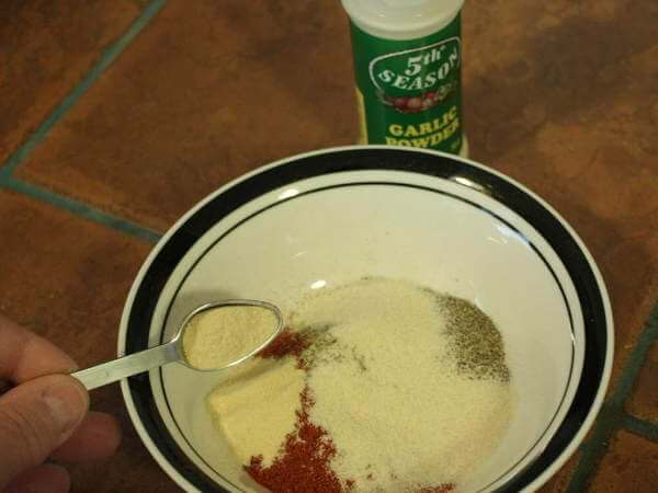 Adding Teaspoon Full of Onion Powder To Bowl of Unmixed Dry Rub Ingredients